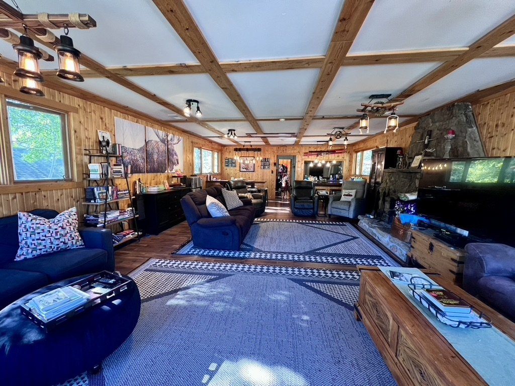 Wide view of the Moose Lodge meeting room with sofas and wood beams